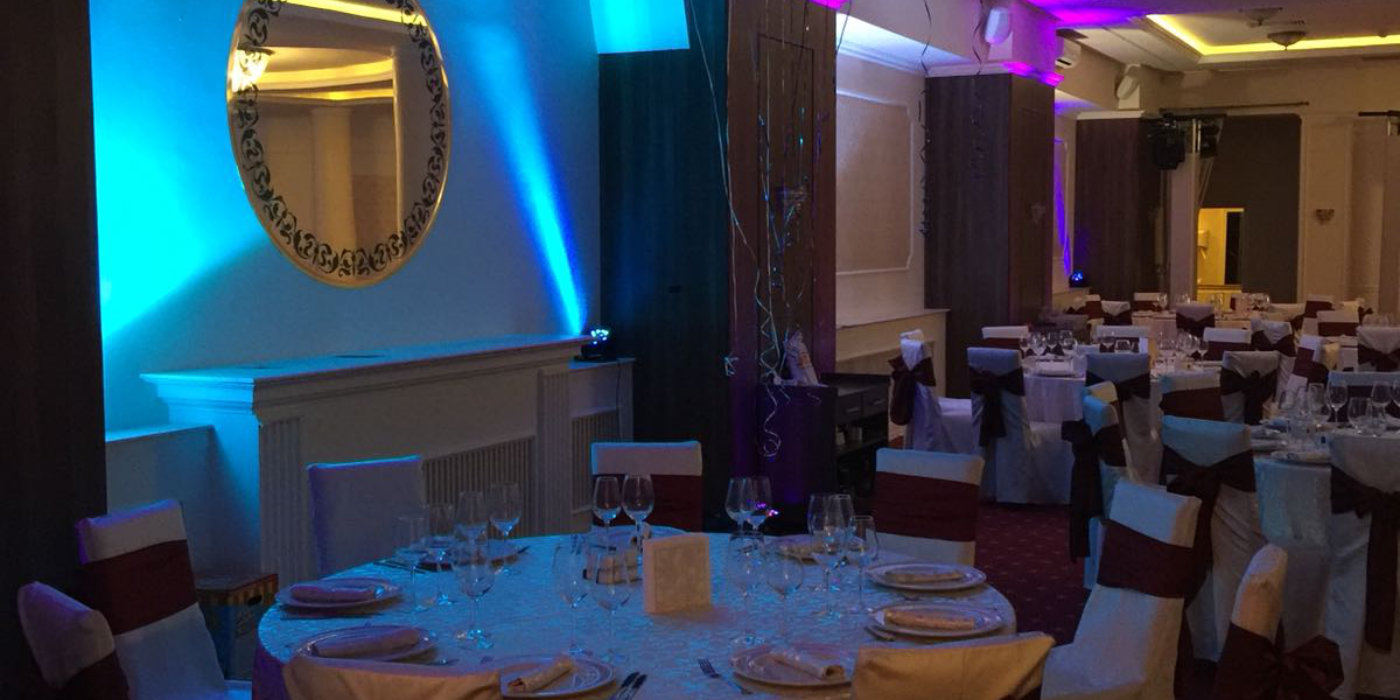 Sala de eveniment decorata cu lumini arhitecturale cu nunate de albastru si mov