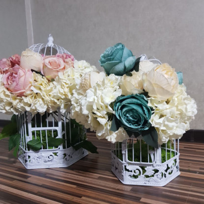 Doua colivii florale cu flori albe, roz si albastre