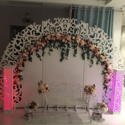 Panou floral incadrat de stalpi luminati in nunate de rosu si mov