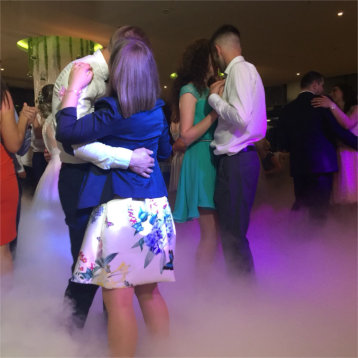 Perechi dansand la petrecere cu efect de fum la picioare